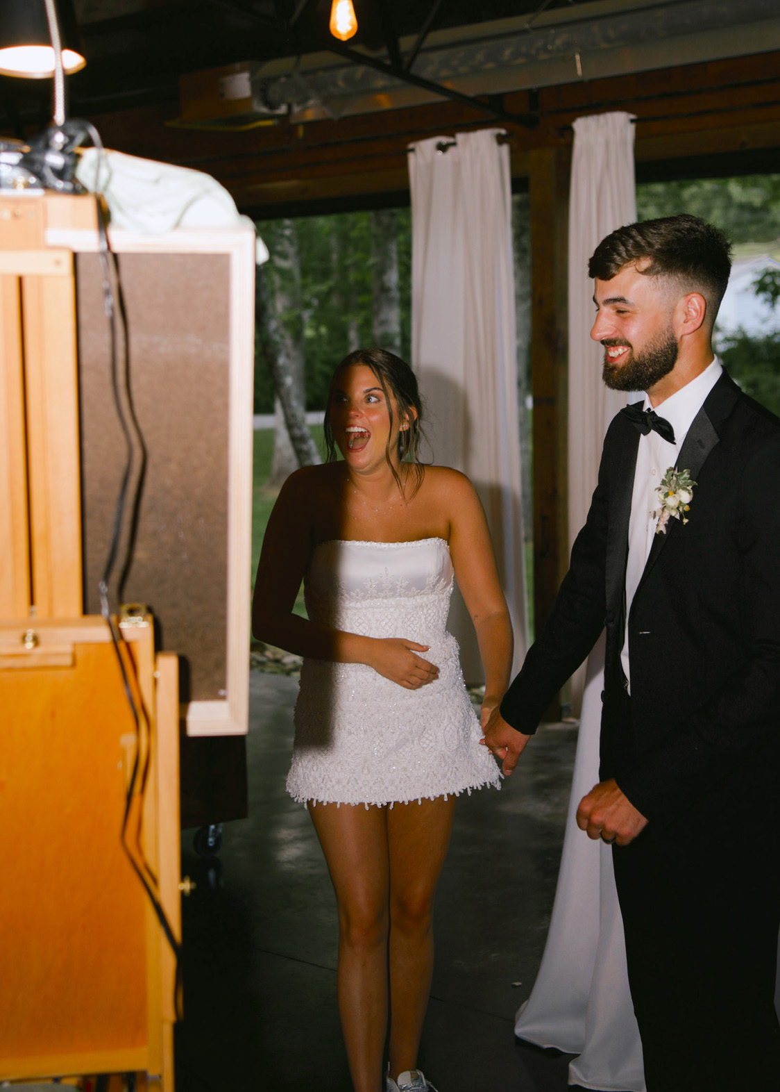 Bride and groom reacting to their live wedding painting at the reception